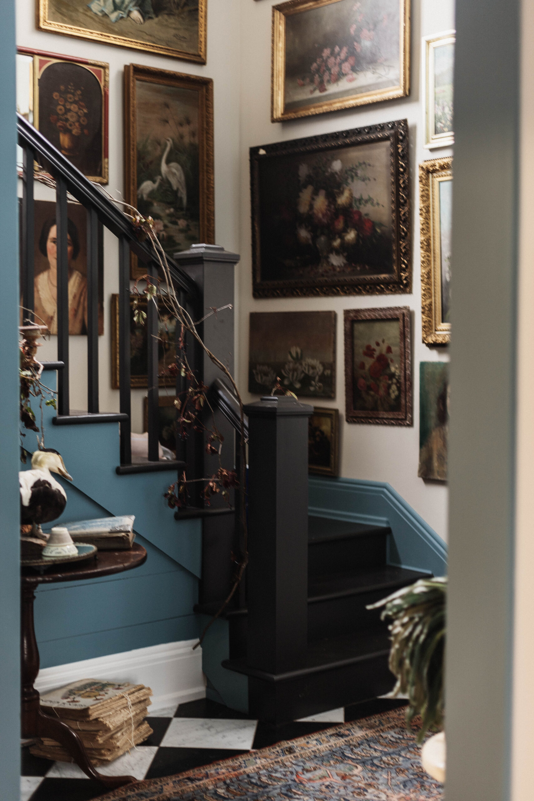 Hallway to the back entrance of my victorian farmhouse. We hung all of my collected antique oil portraits from floor to ceiling. 