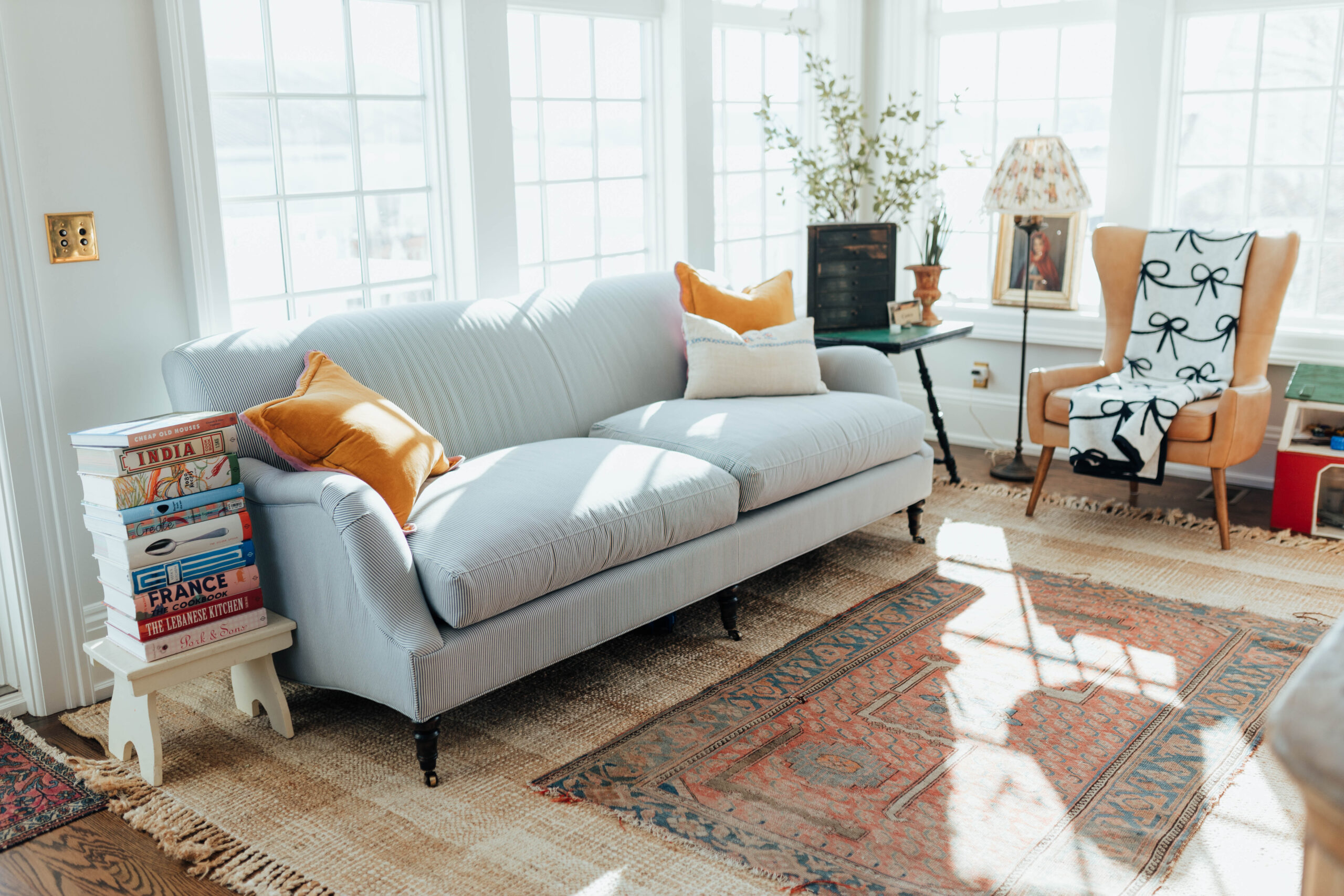 Blue and white tufted couch with plaid jute rug