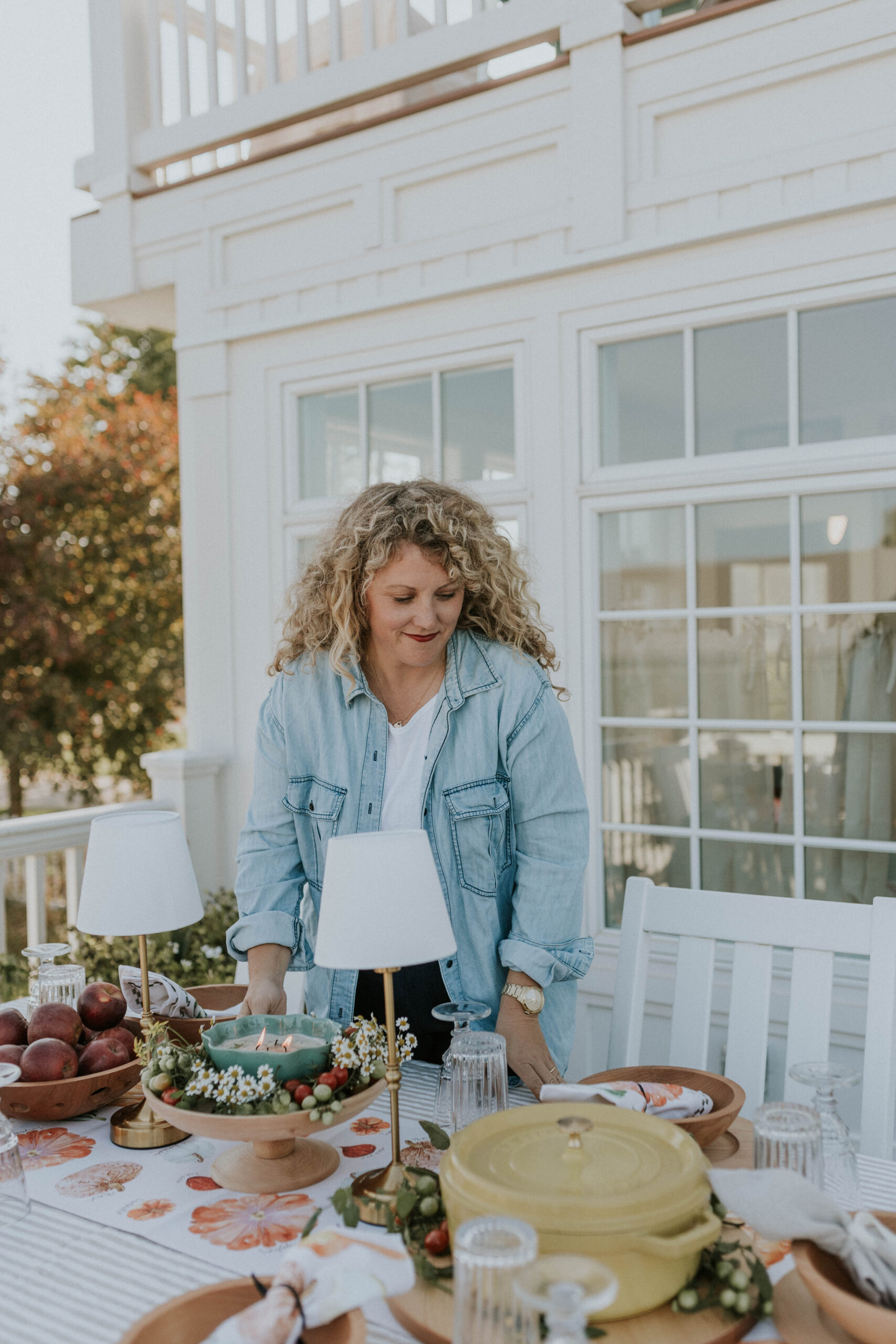 Woman in denim shirt serving food in locally made wooden bowl
